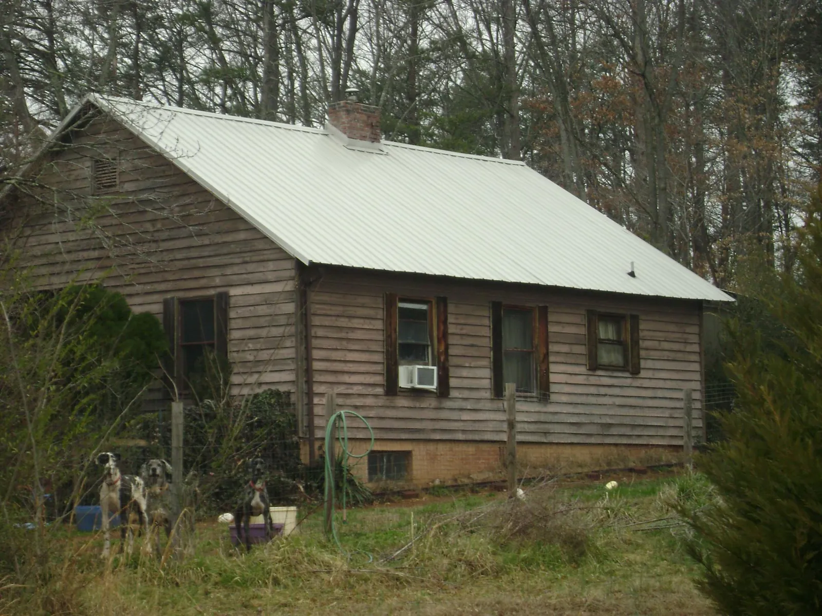 White metal roof on an old wood sided farmhouse, from a Metal Roof Installation job in San Antonio